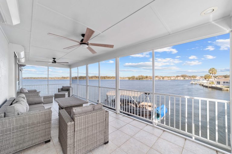 Screened waterfront balcony with comfortable seating