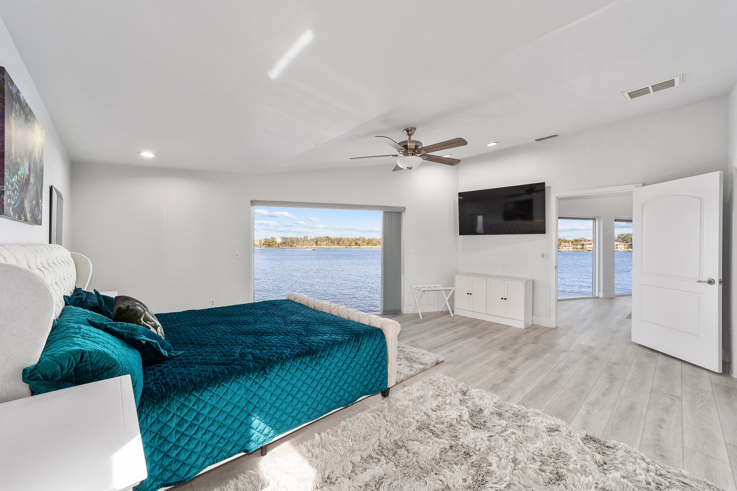 Waterfront primary bedroom with a king bed