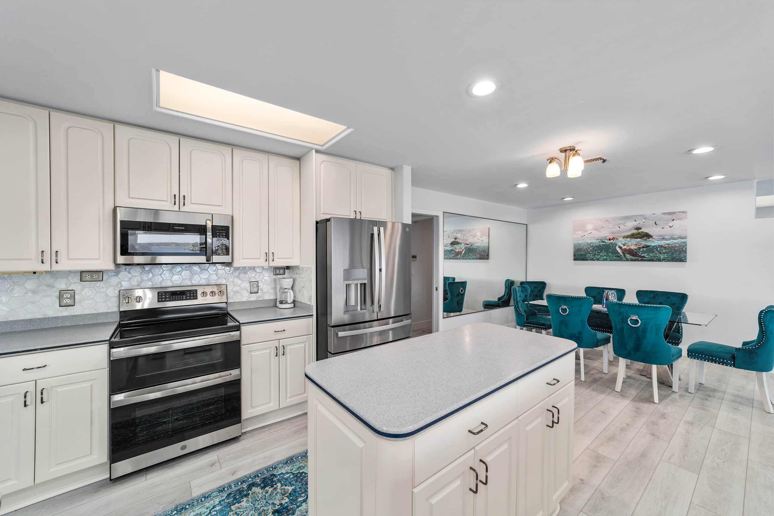 Bright full kitchen with stainless appliances and breakfast bar