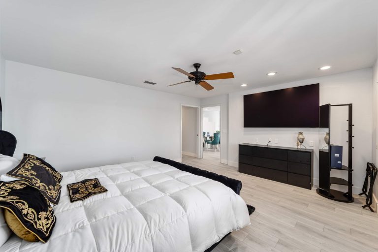 King bedroom with television and adjoining water view